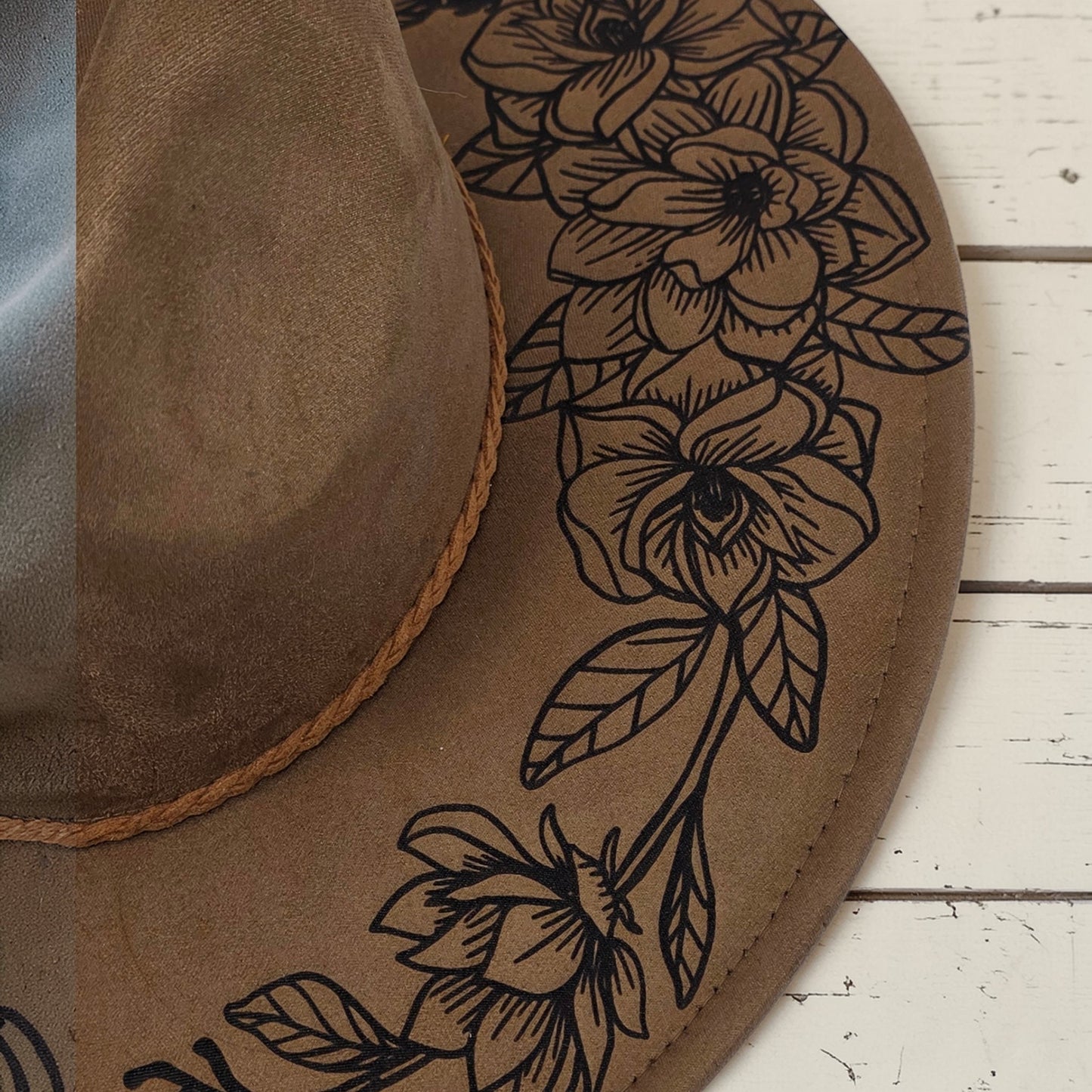 Elkhorn Designs chestnut vegan suede wide brim hat with intricate laser-engraved gardenia floral pattern on the brim.