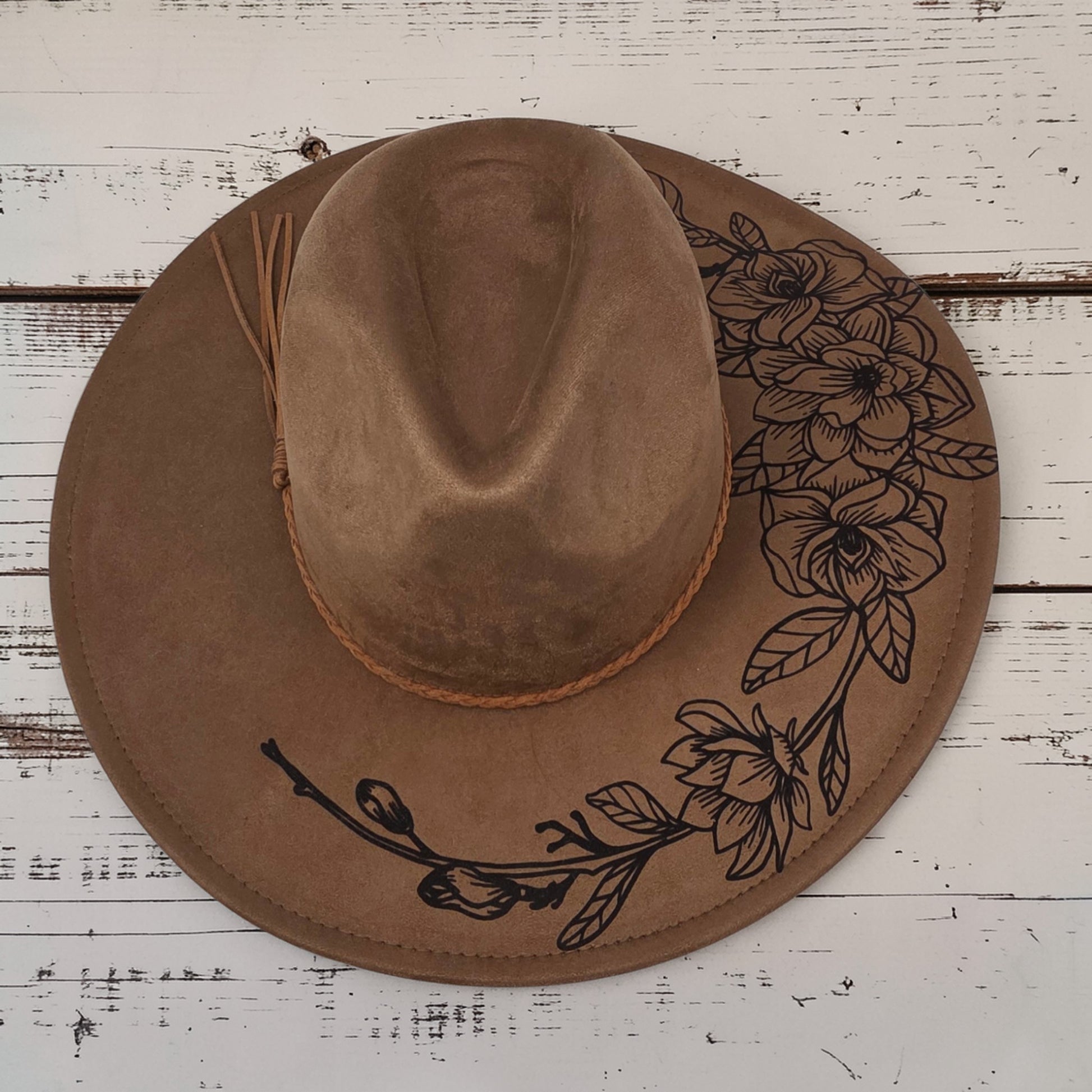 Elkhorn Designs chestnut vegan suede wide brim hat with laser-engraved gardenia floral design and braided tassel band.